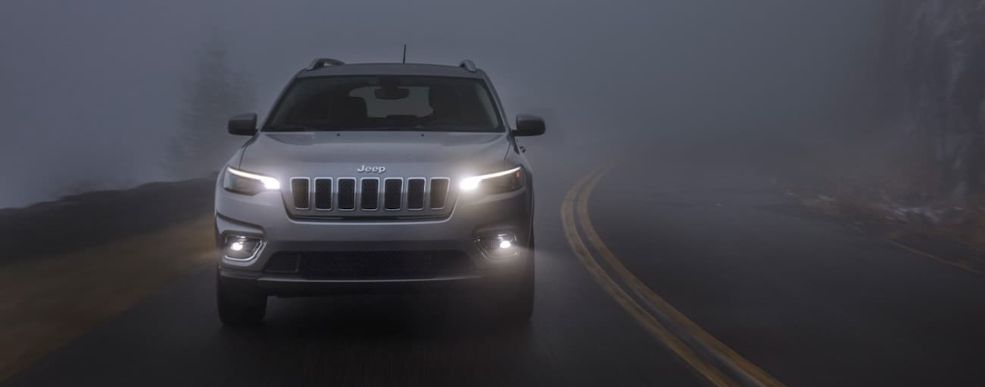 Silver 2020 Jeep Cherokee driving through fog