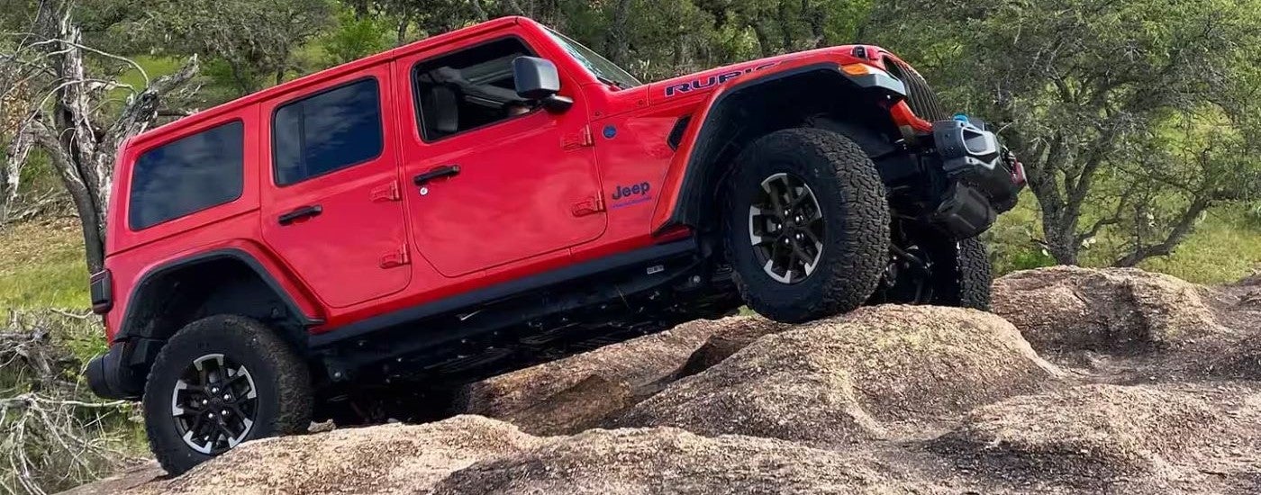 Red 2024 Jeep Wrangler 4xE parked on a rock