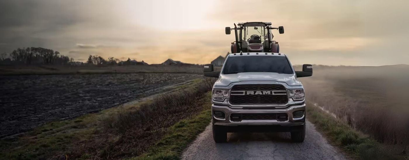 Silver 2026 Ram 2500 towing a tractor