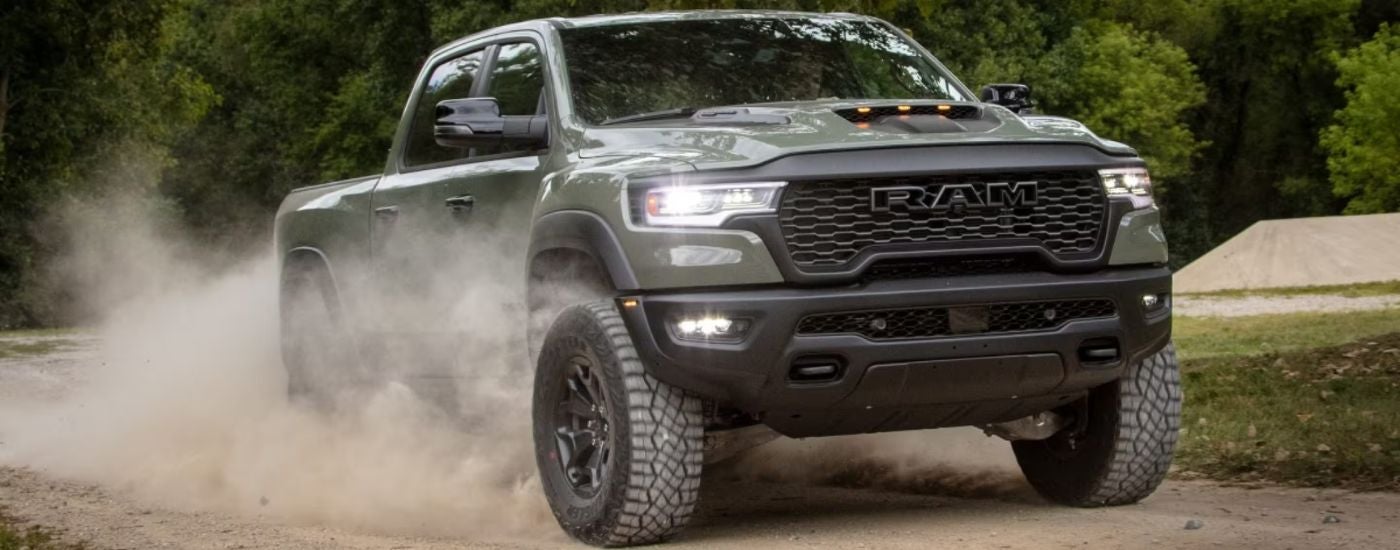 Green 2026 1500 RHO driving on a dirt road.