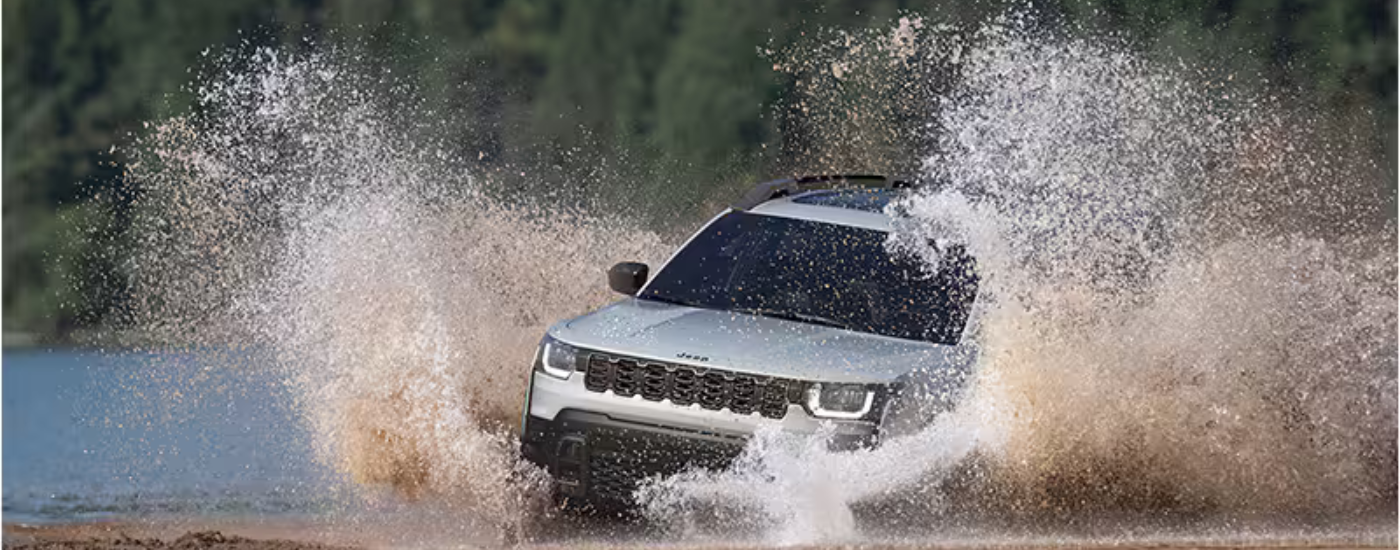 Silver 2026 Jeep Cherokee driving through water