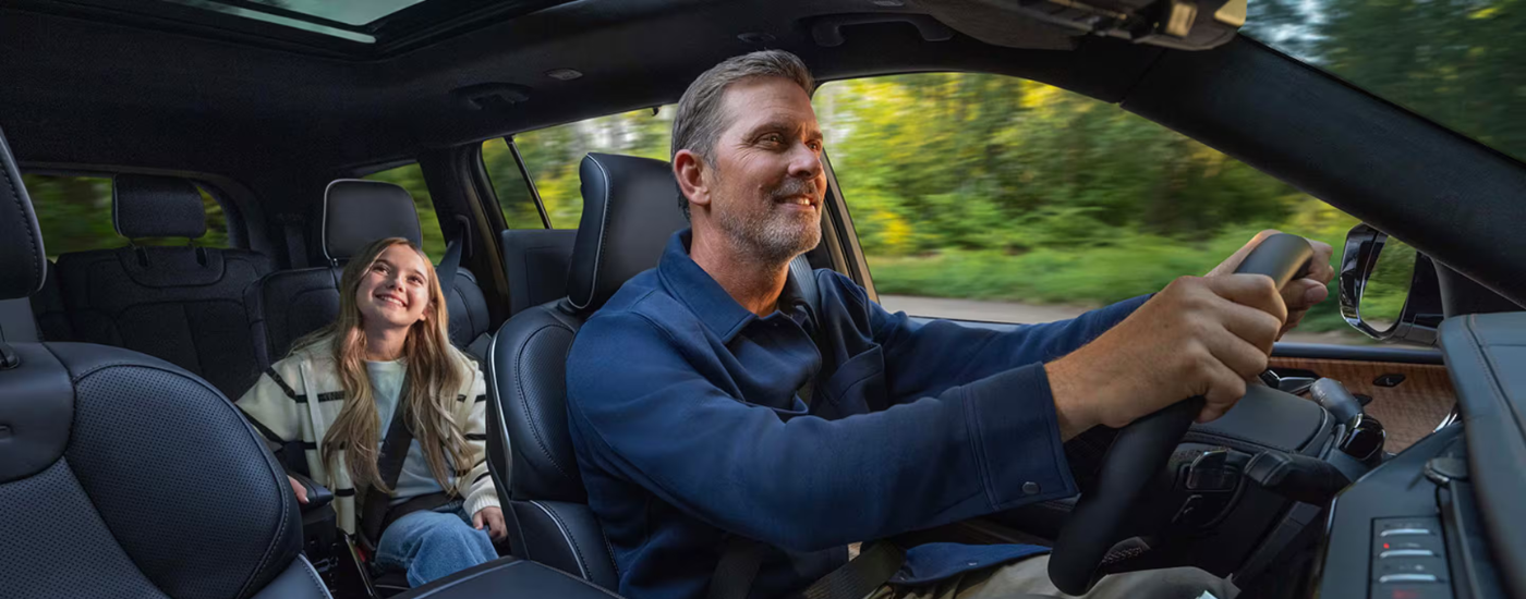 A parent and child driving in a 2026 Jeep Grand Cherokee