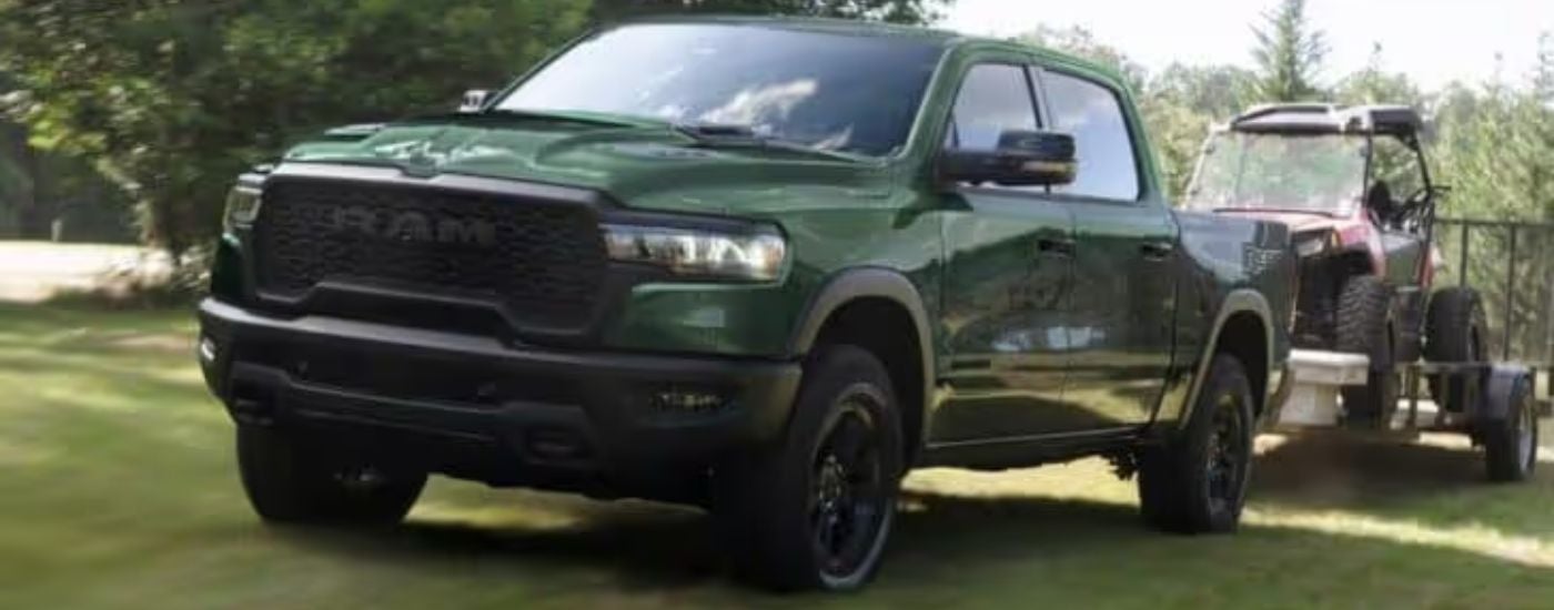 A green 2024 Ram 1500 is shown towing a side by side.