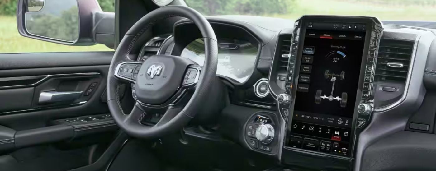 Interior view of a 2026 Ram 1500 steering wheel and touchscreen display.