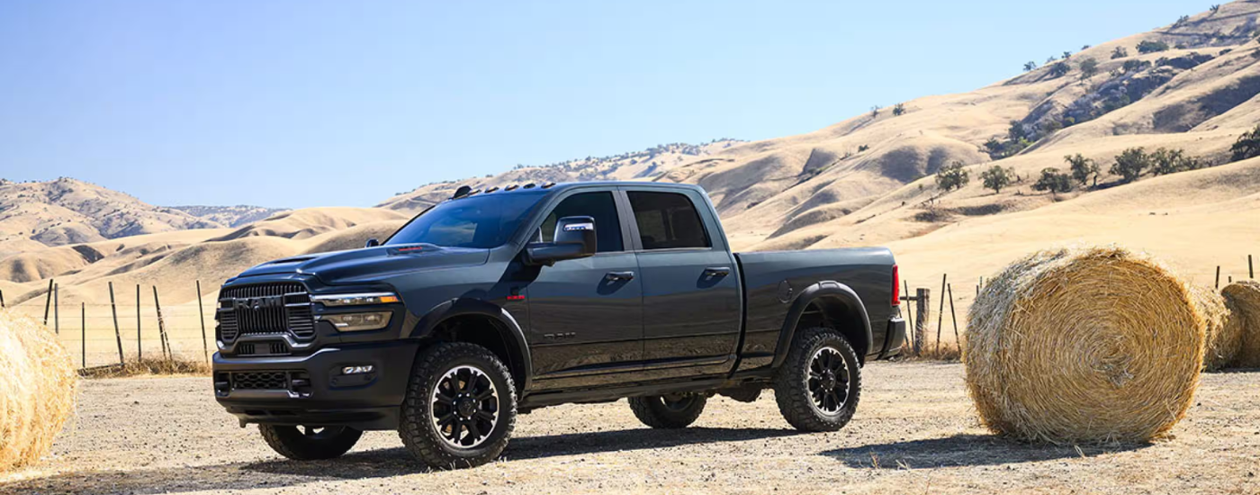 Black 2026 Ram 2500 parked next to a hay bale
